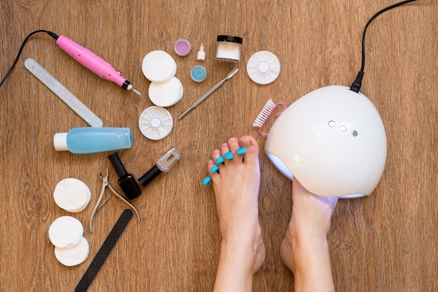 Pedicure a casa con smalti e lampade UV, lime per unghie e forbici