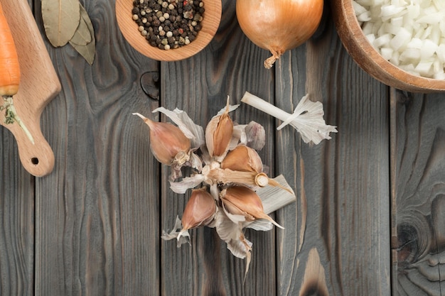 Peeling di aglio piccante Dividere la testa d'aglio in nidi sul tavolo di legno della cucina Vista piatta Aromi fragranti