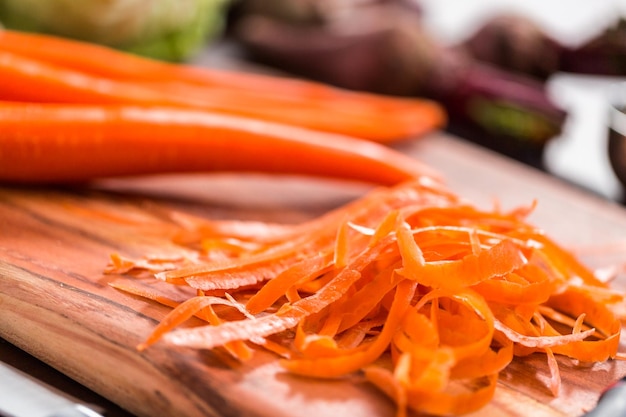 Pelare le carote biologiche per fare la zuppa di barbabietole.