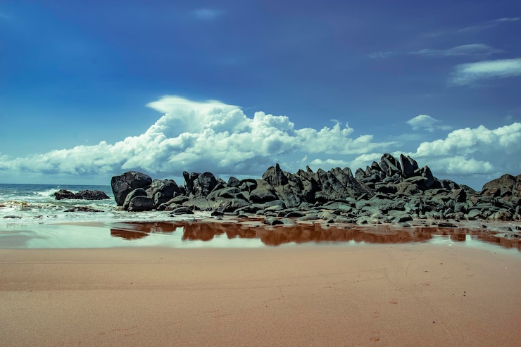 Photo pemandangan indah bebatuan di pantai dengan latar langit