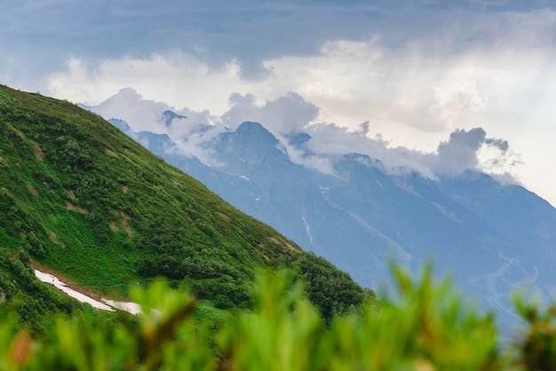 Pendio di montagna verde. Strati di montagne nella foschia durante il tramonto. Sostantivi nebbiosi multistrato