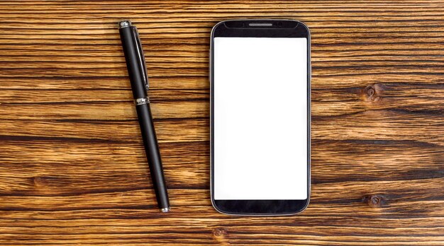 Penna con smartphone sullo sfondo di legno