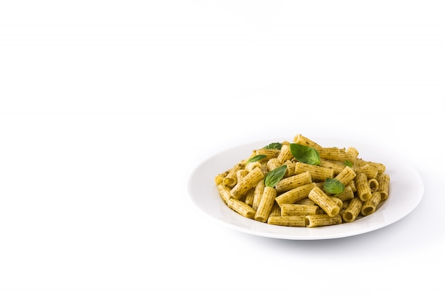 Penne al pesto e basilico su un piatto isolato su superficie bianca. Copia spazio