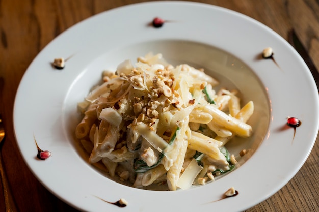 Penne con pollo, spinaci e nocciole in salsa di parmigiano