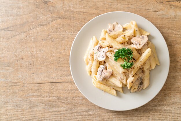 penne pasta alla carbonara salsa di crema con funghi, stile alimentare italiano