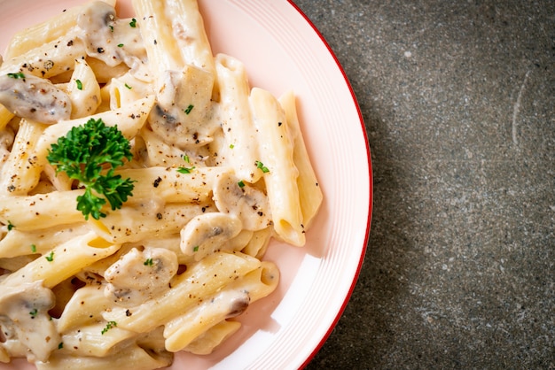 penne pasta alla carbonara salsa di crema con funghi - stile alimentare italiano