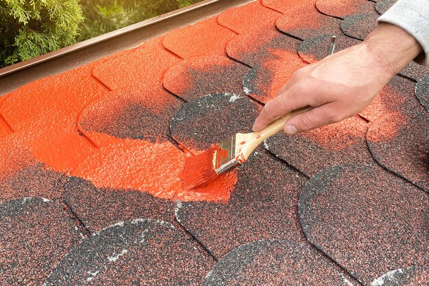 Pennello per pittura casa fai-da-te in mano vernice rossa