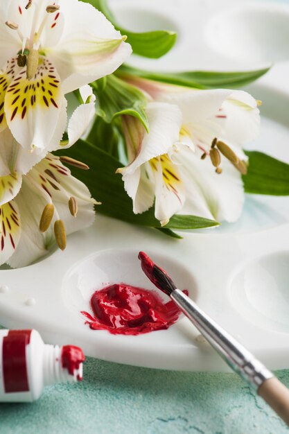 Pennello, vernice rossa dell'acquerello con fiori di primavera