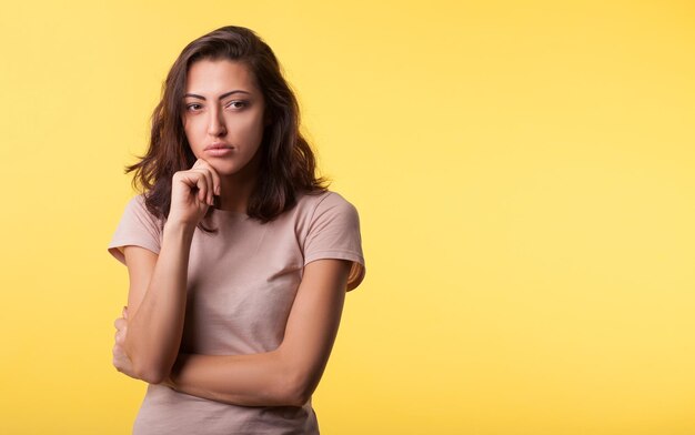 Pensando felice sorriso persone concetto Ritratto ravvicinato di dolce bella e attraente ragazza sbalorditiva su sfondo giallo isolato