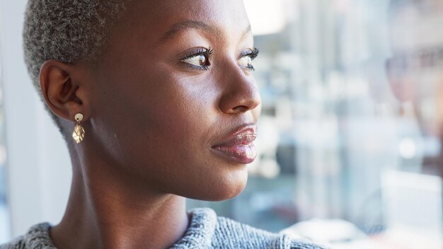 Pensare professionale e donna di colore vicino alla finestra in ufficio con idee di brainstorming e pianificazione Business del lavoratore creativo e volto della persona davanti al vetro premuroso per la strategia futura e la soluzione