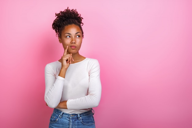 pensiero che posa ragazza mulatta toccando se stessa faccia da dito indice-Immagine