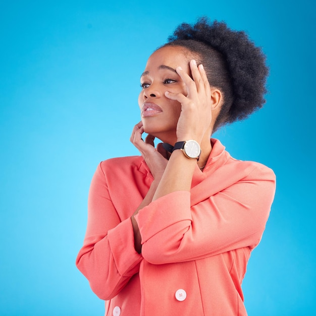 Pensiero debole e donna di colore con la faccia triste moda e vestito elegante su uno sfondo blu studio Persona femminile e modella che si sentono stanchi per l'emozione o il dramma in abiti eleganti e stile alla moda