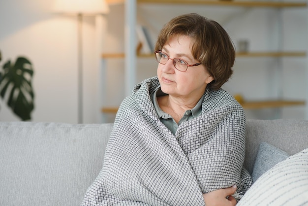 Pensieroso premuroso signora di mezza età che guarda lontano sedersi da solo a casa sentirsi ansioso solitario triste depresso malinconico vecchia donna matura soffre di dolore dolore pensando al problema soffre di solitudine