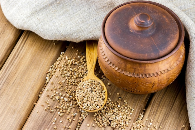 Pentola di grano saraceno in un cucchiaio di legno