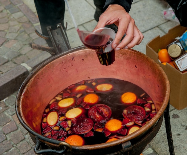 Pentola di rame con vino caldo e frutta