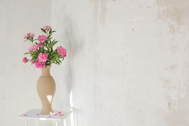 Peonia rosa in vaso di ceramica sul vecchio muro di fondo