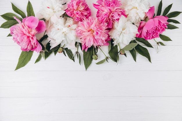 Peonie rosa e bianche su uno sfondo di legno bianco copia spazio piatto biglietto d'auguri