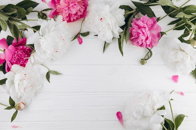 Peonie rosa e bianche su uno sfondo di legno bianco copia spazio piatto biglietto d'auguri