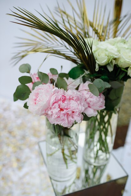 Peonie rosa e rose in una sala per matrimoni