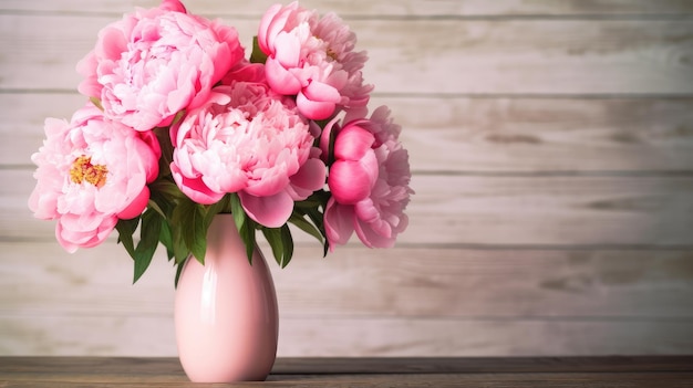 Peonie rosa in un vaso su un tavolo di legno