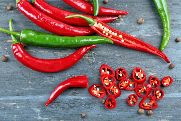 Peperoncini piccanti con spezie sulla tavola di legno si chiudono