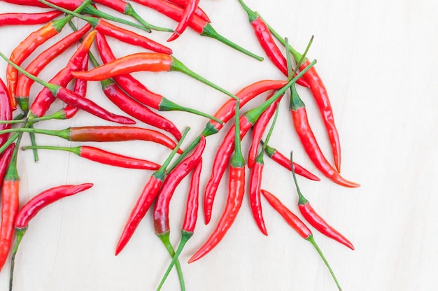 Peperoncini rossi caldi freschi con piccante sulla tavola di legno con lo spazio della copia