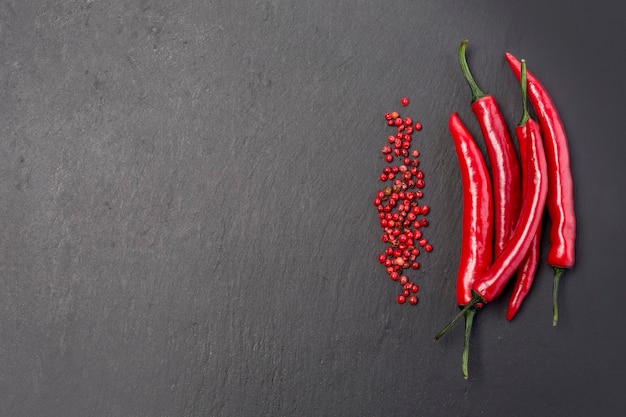 Peperoncini roventi su fondo di pietra nera black