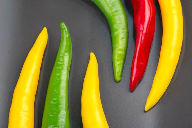 Peperoncino piccante giallo, rosso e verde su un piatto. Pepe. Cibo vitaminico vegetale.