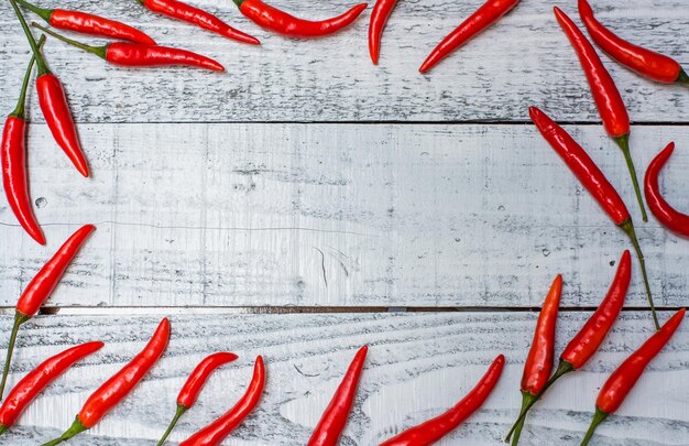 Peperoncino rosso caldo e piccante sul fondo della tavola di legno