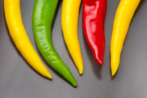 Peperoncino rosso caldo giallo, rosso e verde su un piatto. Alimento vitaminico vegetale.