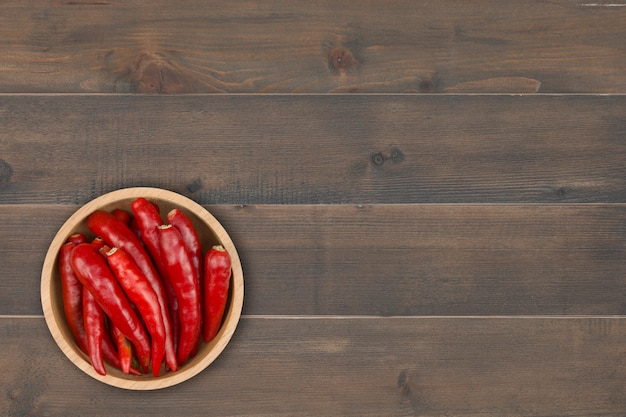 Peperoncino rosso in ciotola sulla tavola di legno