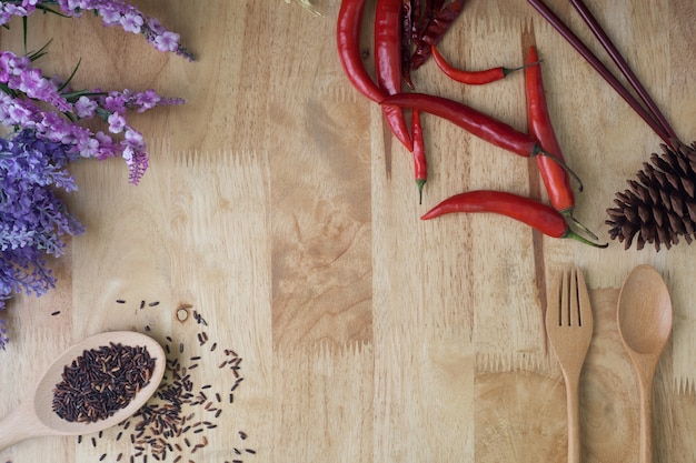 Peperoncino rosso, riso e cucchiaio di legno su fondo di legno