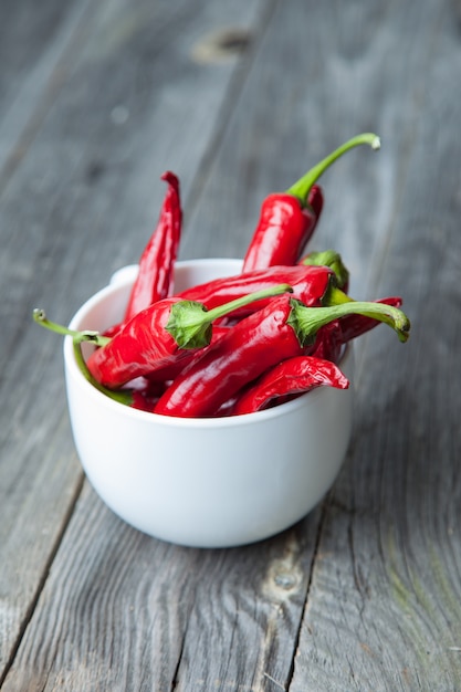 Peperoncino rosso sul piatto su fondo di legno grigio