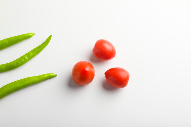 Peperoncino verde fresco e pomodori su sfondo bianco