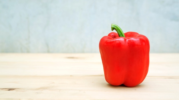 Peperone rosso su un tavolo di legno.