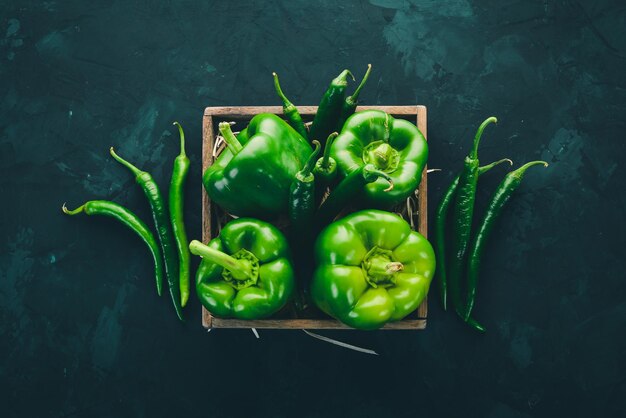 Peperone verde fresco e peperoncino in una scatola di legno Vista dall'alto Spazio libero per il testo