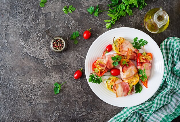 Peperoni ripieni con ricotta e pancetta nel piatto sul tavolo.