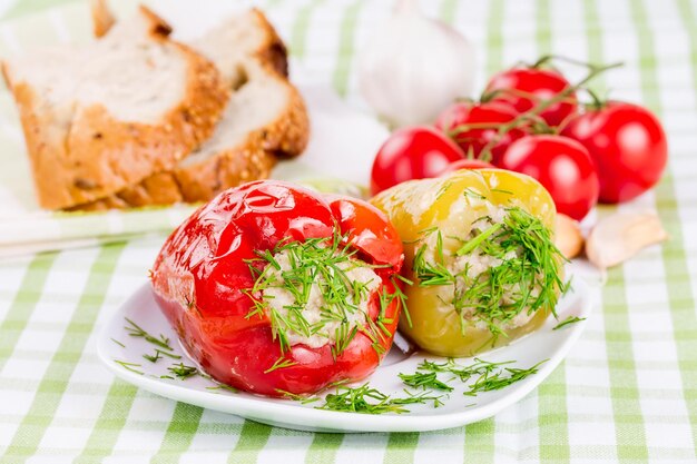 Peperoni ripieni rossi e verdi su un piatto bianco