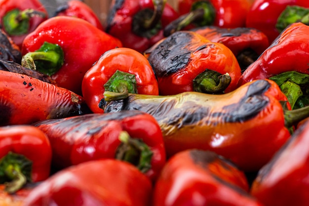 Peperoni rossi arrostiti su una stufa a legna in preparazione per la preparazione dell'ajvar, un piatto tradizionale serbo