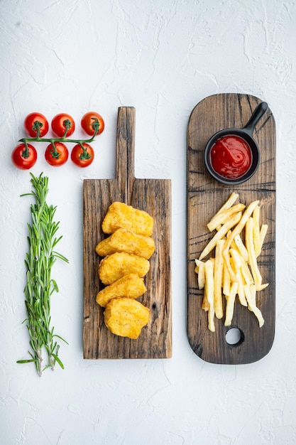 Pepite di petto di pollo fritte su sfondo bianco, vista dall'alto.