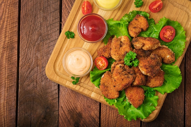 Pepite e salsa di pollo su una tavola di legno