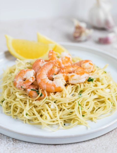 Per pranzo deliziosa pasta con gamberi su un piatto bianco