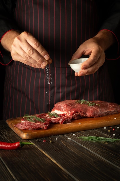 Per rendere la carne saporita è necessario aggiungere sale Lo chef sala la carne prima di friggere o arrostire