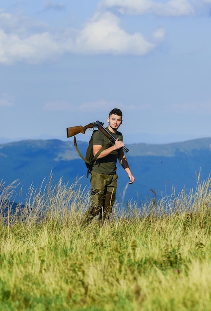 per un domani migliore. soldato in campo. poligono. l'uomo muscoloso tiene l'arma. scopo e successo. uomo pronto a sparare. hobby del cacciatore. forze dell'esercito. il cecchino raggiunge l'obiettivo. stile militare. maschio in mimetica.