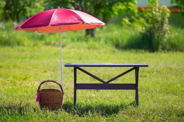 Per un picnic Su un prato verde c'è un tavolo di legno un cesto di vimini