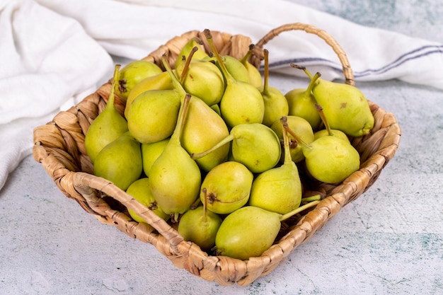 Pera fresca Pere mature in un cesto su uno sfondo di pietra Pera sfusa da vicino