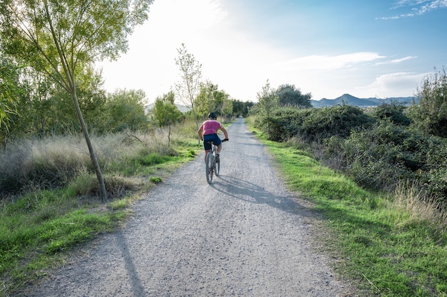 Percorso di campagna con un ciclista al tramonto