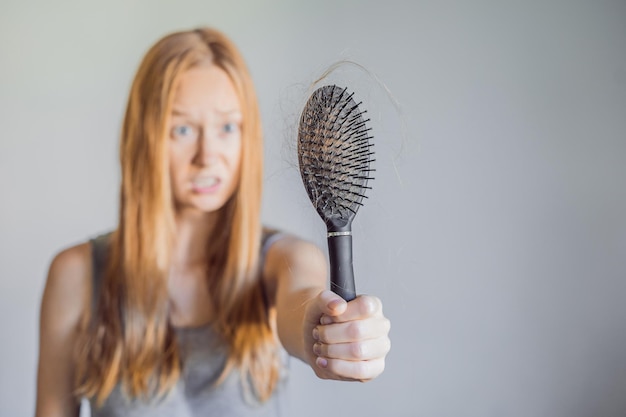 Perdita di capelli nel concetto di donne Molti capelli persi sul pettine