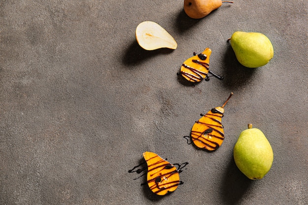 Pere dolci con salsa su superficie grigia