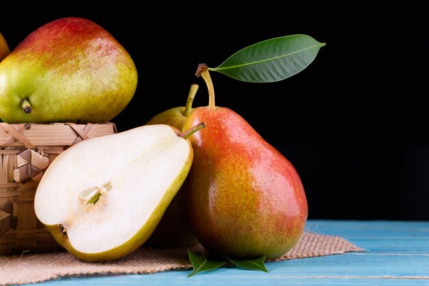 Pere fresche con foglie su fondo di legno